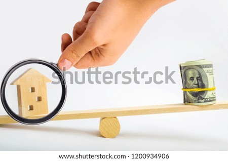 house and dollars on the scales. balance. buying, selling, renting a house and an apartment. credit. mortgage. property. investment in real estate. saving money. Home loan