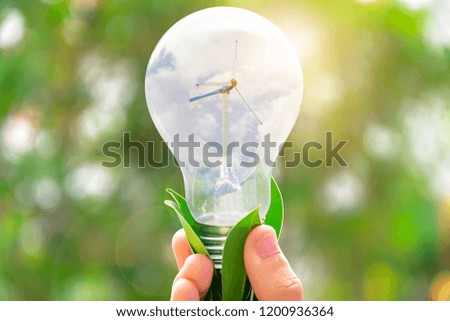 Wind turbines used to generate electricity in the bulb, By the hand holding it. Renewable energy is a necessity of the future world, Future Energy.