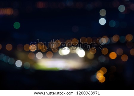 Blurry picture of a football stadium at night, with lots of bokeh and blown out lights