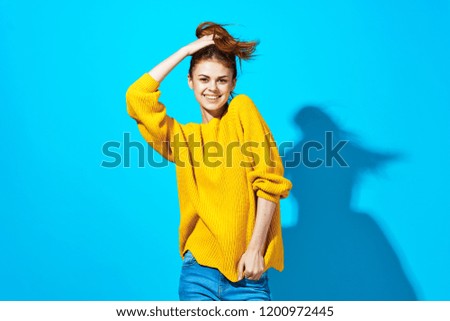 pretty woman in a sweater on a blue background                           