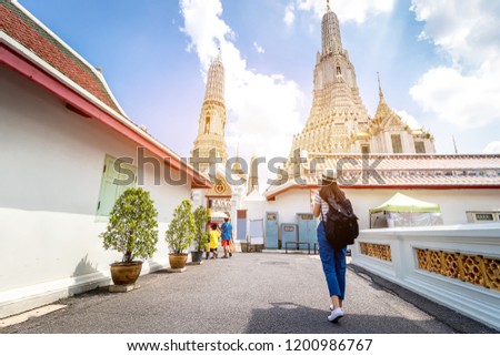 Tourist women with Carrying a backpack Viewing poster, About the temple in Bangkok At Arunratchawararam Temple.Concept Travel in relax.