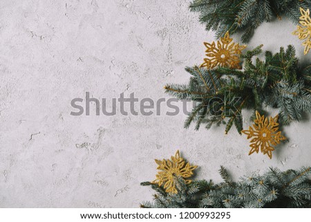cropped image of handmade Christmas tree with snowflakes hanging on grey wall in room