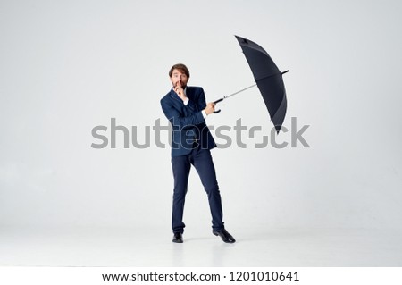 man in a suit holds in his hand an open umbrella                          
