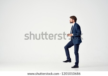man in a suit in full growth on a light background                               