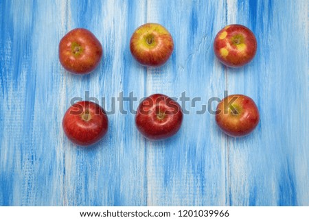 Apples on a blue wooden background. Red and yellow farm apples.