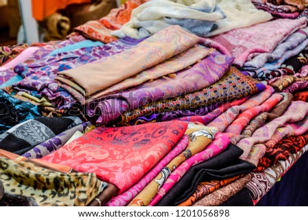 Indian fabrics folded on the counter. Trade in fabrics from india. Fabric with patterns and patterns.