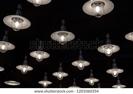 A lot of light Bulbs with shades on a dark background