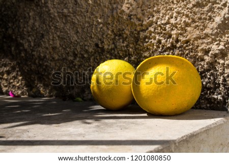 Wall of a house with two enlightened oranges from the fresh harvest. Mountain village Archanes, Crete, Greece.