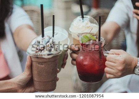 Cheers cliking of group friends with strawberry soda juice, choccolate and icced coffee.