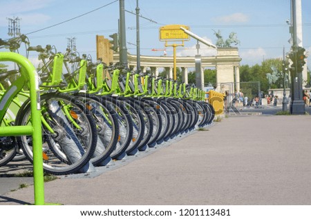 Green city bikes stand in a row for driving through the streets, the theme of bikes and infrastructure of the city
