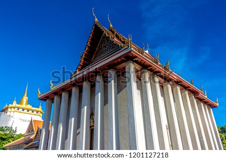 The roof of buddhist temple Bangkok Thailand. Isosceles triangle shape Blue sky background.