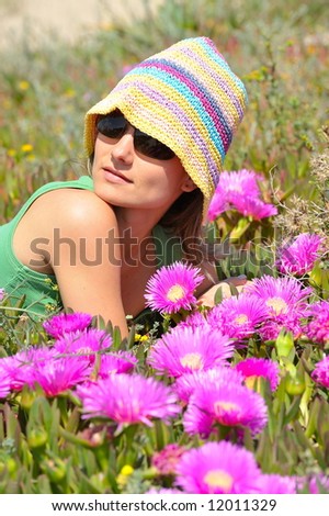 attractive girl on a field with colorful flowers on a summer day