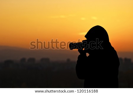 Silhouette of photographer taking pictures of sunset