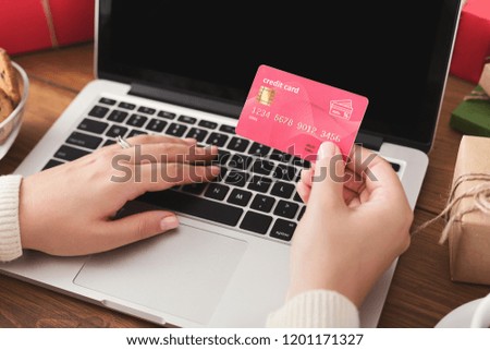 Christmas sales. Woman shopping online on laptop with credit card, closeup
