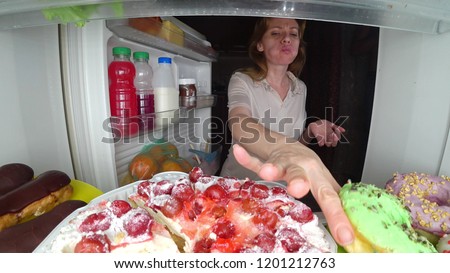 Woman opens the refrigerator at night. night hunger. diet gluttony Royalty-Free Stock Photo #1201212763