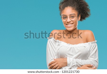 Young afro american woman wearing glasses over isolated background happy face smiling with crossed arms looking at the camera. Positive person.