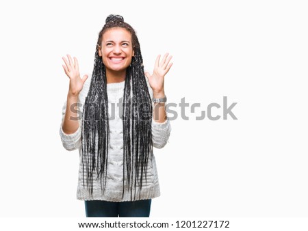 Young braided hair african american girl wearing sweater over isolated background celebrating mad and crazy for success with arms raised and closed eyes screaming excited. Winner concept