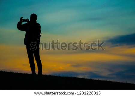 Male silhouette standing in the sunset of the hill