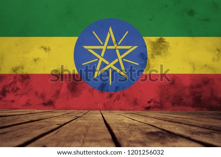 The floor of planks and plastered wall with a painted Ethiopia   flag.