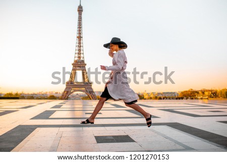 Woman jumping on the famous square with great view on the Eiffel tower early in the morning in Paris