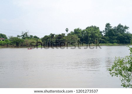 Landscape picture of  fisherman rows a boat for fishing in the middle of river.