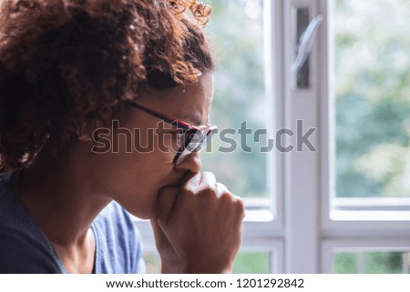 Lonely black woman near window thinking about something Royalty-Free Stock Photo #1201292842