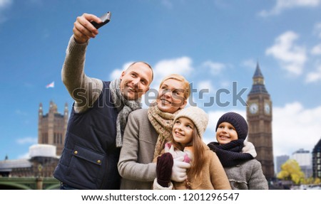 family, travel and tourism concept - happy mother, father, daughter and son taking selfie by smartphone over big ben tower in london city background