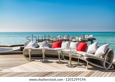 Vacation net seat in tropical Maldives island and beauty of the sea with the coral reefs. Modern sofa and chairs in luxury beach resort with relaxation sea view.
