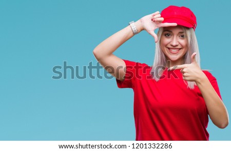 Young blonde woman wearing red hat over isolated background smiling making frame with hands and fingers with happy face. Creativity and photography concept.