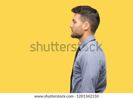 Young handsome business man over isolated background looking to side, relax profile pose with natural face with confident smile.