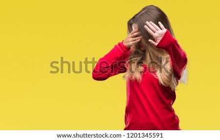Young beautiful blonde woman wearing red sweater over isolated background covering eyes with hands and doing stop gesture with sad and fear expression. Embarrassed and negative concept.