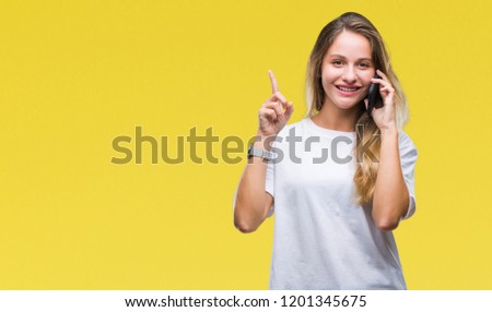 Young beautiful blonde woman calling using smartphone over isolated background surprised with an idea or question pointing finger with happy face, number one