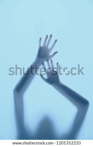 Shadow hands of the woman behind the white curtain