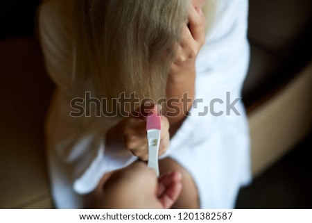 Young woman is sad about result of pregnancy test