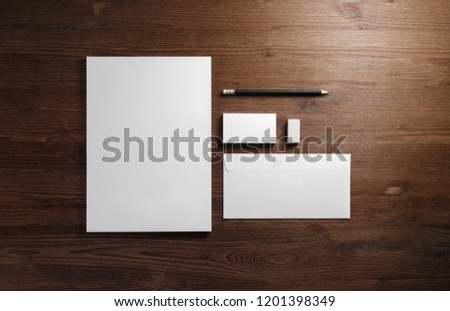 Photo of blank corporate stationery on wood table background. Branding mock-up. Flat lay.