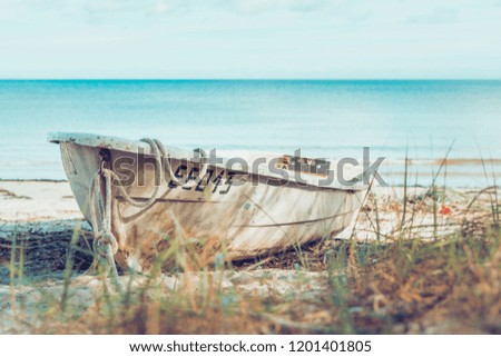 Old fashioned boat on the seaside beach in autumn. Tranquil and peaceful scenery. Sandy beach of Latvian coastline.