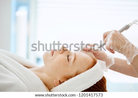 Caucasian woman getting face peeling procedure in a beauty clinic, close up. Rejuvenating facial gas liquid treatment. Hydro air skin cleansing operation. Royalty-Free Stock Photo #1201417573
