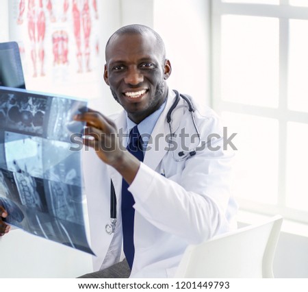 Portrait young african medical doctor holding patient's x-ray