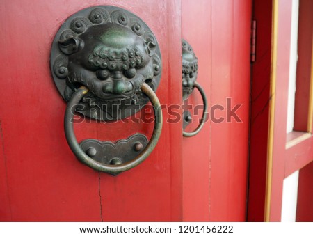 dragon head door knocker on a red door