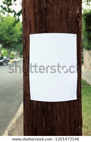 Blank sign stapled to a telephone pole Royalty-Free Stock Photo #1201473148