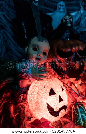 Halloween decorations: a doll playing with a scary pumpkin