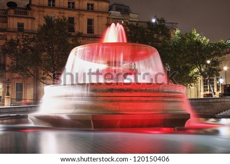 red lit fountain on Trafalgar square at night