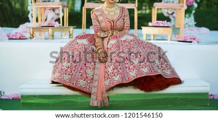 Pakistani Indian bride showing red lehenga and wedding jewelry Royalty-Free Stock Photo #1201546150