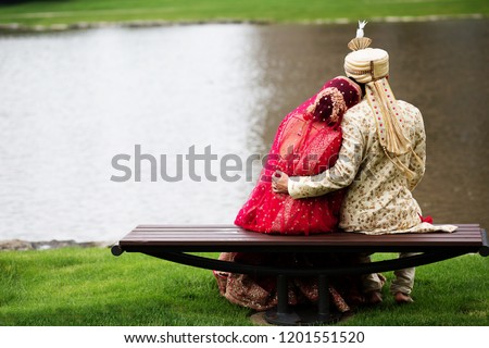 Indian bride and groom treasured moments and wearing red Sharara, sharwani Royalty-Free Stock Photo #1201551520