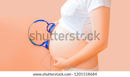 Pregnant girl with a belly in a white T-shirt
