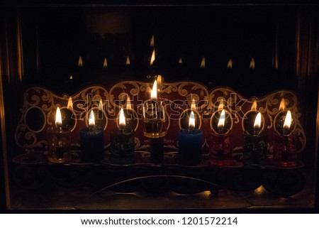 A Jewish tradition in Hanuka holiday is to put the lighted Hanuka's Menorah near the windows and even in glass boxes outdoor as shown in the pictures. Each day we light one more candle up to 8 candles