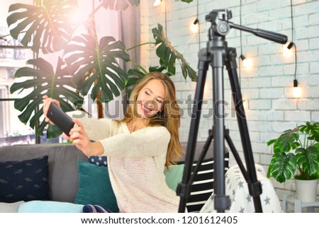 Blogging concept. Girl makes blog with smartphone at home. 