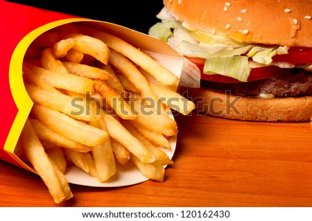 fast food set big hamburger and french fries on black background.