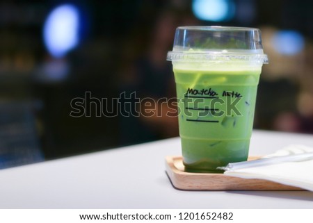 Iced matcha green tea latte on table in store.