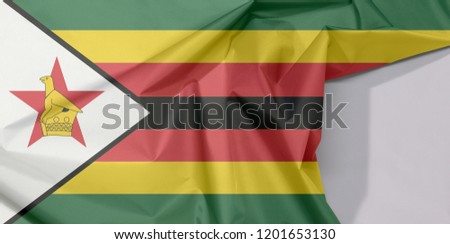 Zimbabwe fabric flag crepe and crease with white space, seven horizontal stripes of green yellow red black with a black-edged white with a bird on a red star.